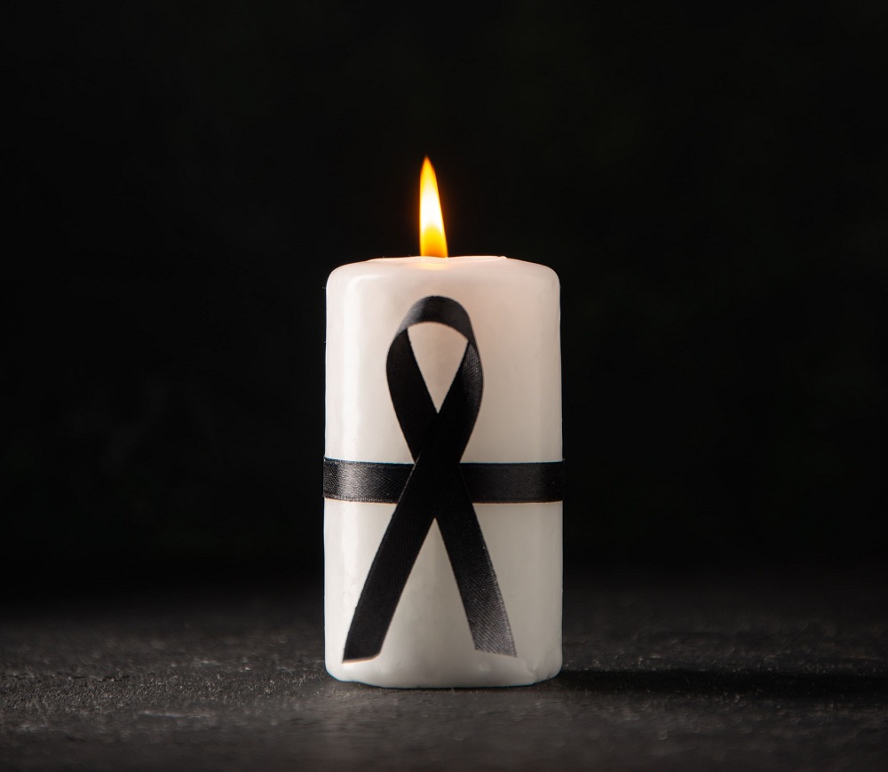 imagem de uma vela com fita simbolizando o luto